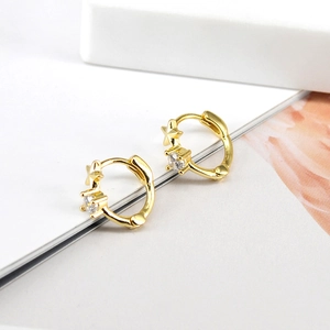 Detailed macro view of gold-plated star earrings with round-cut cubic zirconia