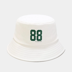 Detail shot of a white cotton bucket hat with green 88 embroidery and street style text