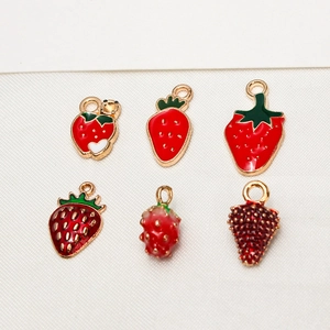 Macro detail of six red strawberry alloy pendants with diverse textures and leaf patterns