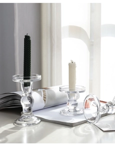 Close-up of three clear glass Roman pillar candle holders with minimalist design aesthetics