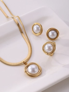 Close-up of gold mesh wrap pearl jewelry set with necklace earrings and ring on tray