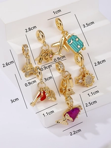 Macro view showing dimensions of various gold-plated travel-themed jewelry charms