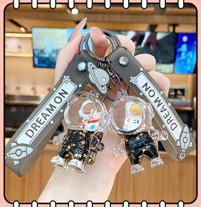 Detail of liquid quicksand astronaut keychain with hand-held view and star patterns