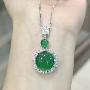 Close-up of a green chalcedony pendant necklace with shimmering diamond accents on the wrist
