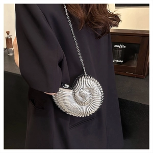 Close-up of a silver snail-shaped evening bag with metallic finish and fine chain strap