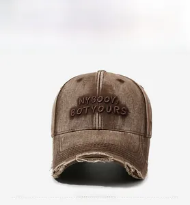 Detail of distressed brown baseball cap featuring NYBOOY embroidered letters and frayed brim