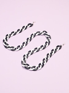 Chic black and white acrylic eyeglass chain in S-curve layout on purple background