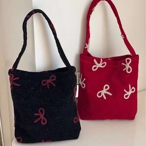 Sac à main en tricot élégant avec broderie nœud en rouge et noir, détail de marque