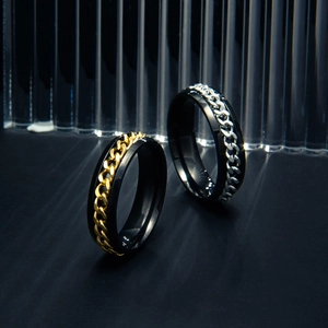 Close-up of black stainless steel rings with gold and silver chain inlay detail