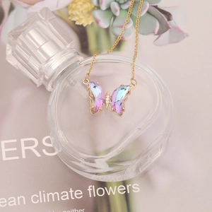 Detailed shot of a butterfly necklace with gradient crystals on a gold chain
