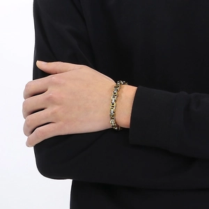 Détail du bracelet byzantin bicolore en acier inoxydable porté sur un poignet masculin