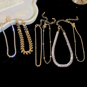Detailed close-up of six gold-tone zircon chain bracelets set against a dark backdrop