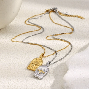 Gros plan détaillé des pendentifs oiseau en or et argent sur un support en pierre chic