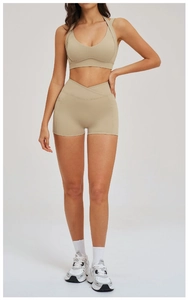 Dettaglio del reggiseno sportivo con scollo a V incrociato e pantaloncini da yoga in beige