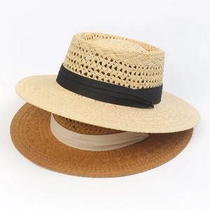 Detailed close-up showing texture of hand-woven straw hats in beige and caramel tones