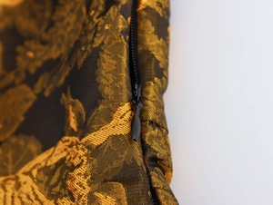 Close-up of invisible zipper and gold floral brocade fabric on a vintage dress