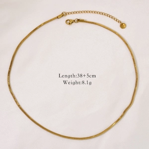 Detail view of 14k gold plated snake chain necklace with lobster clasp on white fabric