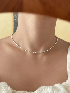 Close-up of a 925 silver necklace with rainbow beads worn on a model neck