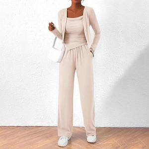 Détail du tissu de l'ensemble trois pièces beige avec cardigan et pantalon large fluide