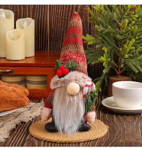 Close-up of a Christmas gnome featuring a knitted snowflake hat and a candy cane