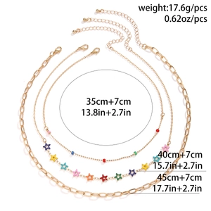 Detailed view of a three-piece gold layered necklace set with colorful star charms and measurements