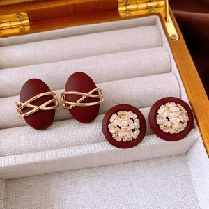 Détail de boucles d'oreilles en résine rouge avec placage or 18K et zircons scintillants
