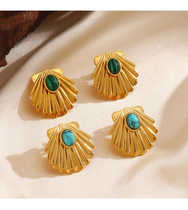 Detail of gold shell earrings featuring green and turquoise stones on cream silk