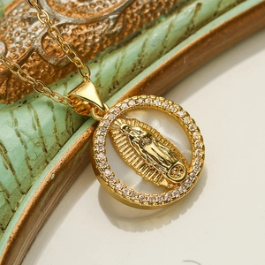 Macro detail of gold-plated Virgin Mary pendant with mother of pearl and cubic zirconia