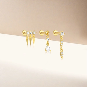 Vue détaillée de trois piercings d'oreille en argent S925 doré avec zircons brillants