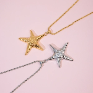Detailed close-up of 18k gold and silver starfish pendants with twisted rope chains