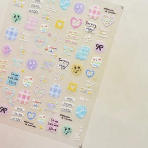 Macro detail of macaron-colored nail stickers with cute heart and bow motifs for journals