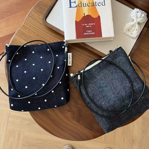 Close-up of minimalist denim crossbody bags with polka dot and stripe patterns