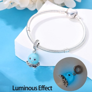 Detailed view of silver octopus charm bracelet with blue stone and luminous glow effect
