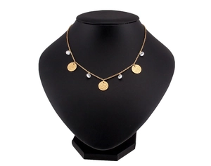 Detail of gold hammer-textured discs and clear zircon pendants on a layered chain necklace