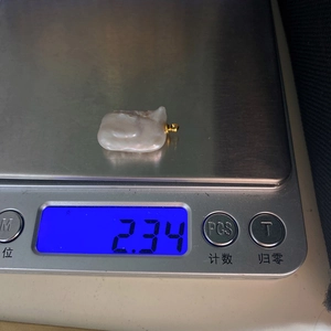 Macro view of a baroque pearl pendant on an electronic scale showing 2.34g weight