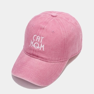 Detailed close-up of pink cotton baseball cap with white CAT MOM embroidery