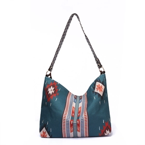 Detailed shot of dark teal boho canvas bag with ethnic geometric patterns and woven strap