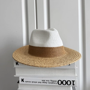 Detailed close-up of two-tone woven raffia sun hat with white crown and brown wide brim