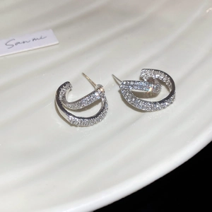 Macro shot of double-layered C-shape earrings with shimmering pavé zircon setting
