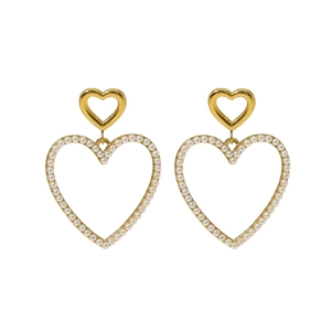 Detailed macro view of gold-plated layered heart earrings with white faux pearl embellishments