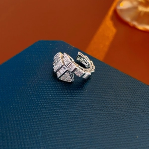 Dettaglio macro dell'anello a serpente in argento con zirconi su base blu testurizzata