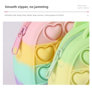 Detail of smooth rainbow silicone zipper and heart-shaped pop bubble fidget purse texture