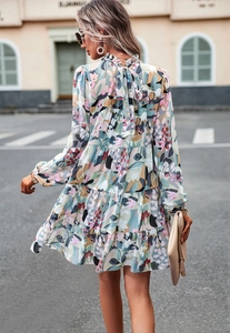 Détail d'une robe maxi fleurie avec volants superposés et un nœud à l'arrière