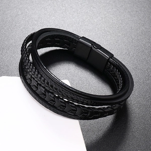 Détail macro du bracelet multicouche en cuir tressé noir avec fermoir magnétique en alliage