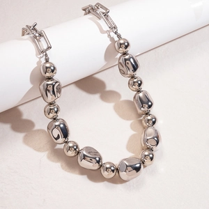 Detail view of silver irregular metallic beads on an industrial rectangular link chain