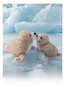 Dettaglio di due peluche a forma di foca marrone con consistenza soffice sulla neve