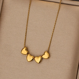 Golden heart pendant necklace with four polished charms on a sleek snake chain