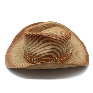 Detail of western straw hat with brown leather band and decorative silver rivets