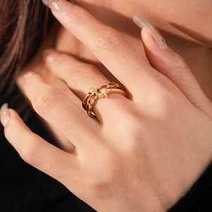 Vue macro de la bague dorée multi-rangs avec charms étoiles et pierres de zircone