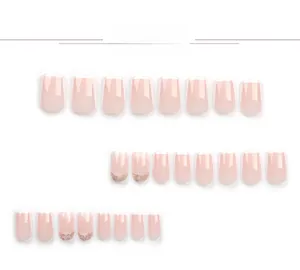 Detailed flat lay of 24pcs French manicured press-on nails with white tips and gold glitter